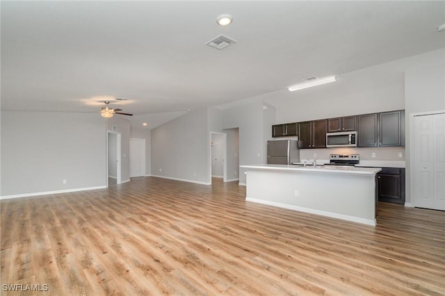 1492 Schenley St, Port Charlotte, FL 33952 - kitchen with freestanding refrigerator, stainless steel microwave, stove, lofted ceiling, and open floor plan