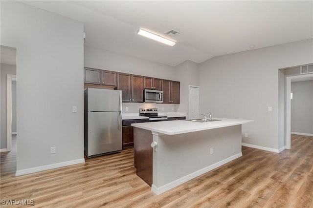 1492 Schenley St, Port Charlotte, FL 33952 - kitchen with stainless steel appliances, dark brown cabinetry, light countertops, vaulted ceiling, and light wood-style floors
