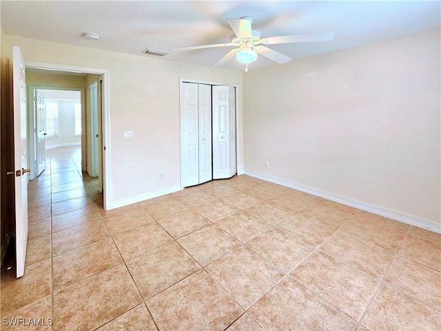 2640 4th Ave NE, Naples, FL 34120 - unfurnished bedroom featuring light tile patterned flooring, a closet, and a ceiling fan