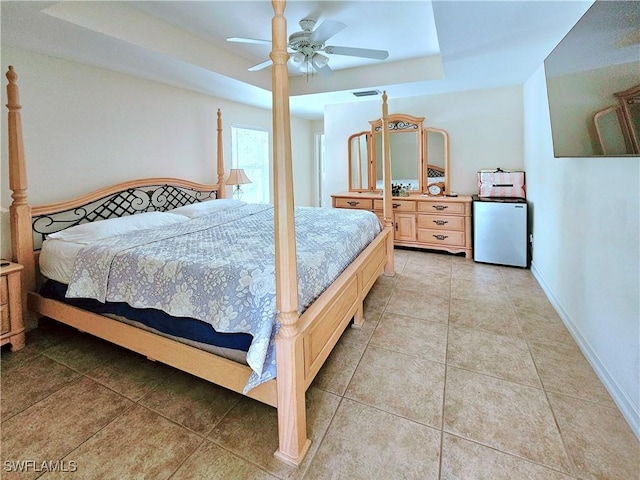 2640 4th Ave NE, Naples, FL 34120 - bedroom featuring a tray ceiling, fridge, light tile patterned floors, and a ceiling fan