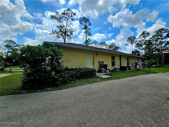 2640 4th Ave NE, Naples, FL 34120 - view of side of property with stucco siding and a central AC unit