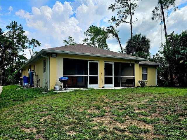 2640 4th Ave NE, Naples, FL 34120 - rear view of house with stucco siding, a yard, and a sunroom