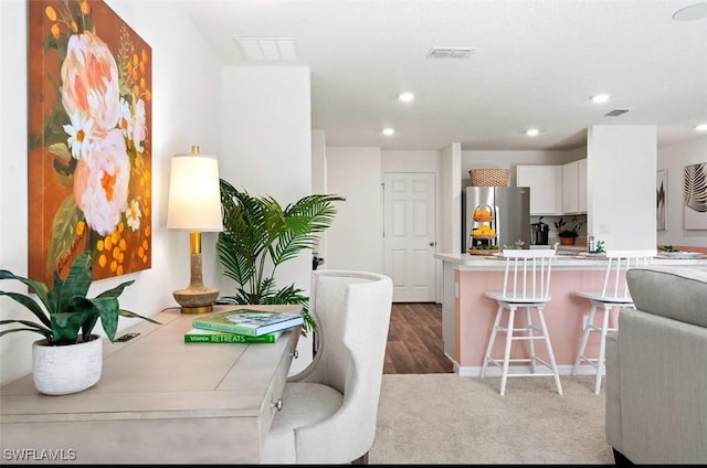 331 NW 19th St, Cape Coral, FL 33993 - kitchen with freestanding refrigerator, a kitchen bar, recessed lighting, white cabinets, and light countertops
