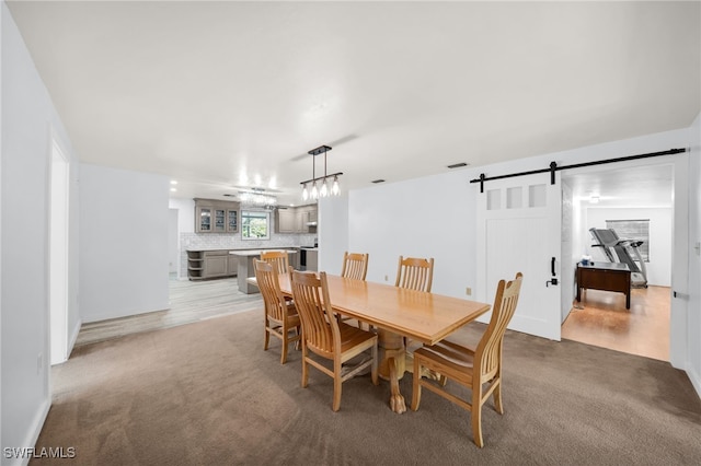 19350 Meredith Rd, North Fort Myers, FL 33917 - dining room featuring light colored carpet, a barn door, and a chandelier