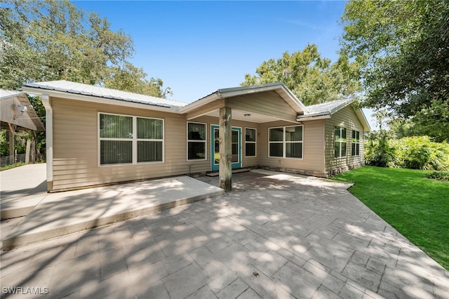 19350 Meredith Rd, North Fort Myers, FL 33917 - rear view of property featuring a lawn, a patio, and a metal roof