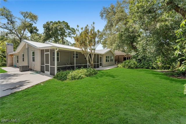 19350 Meredith Rd, North Fort Myers, FL 33917 - back of property with a sunroom, a yard, a metal roof, and a chimney