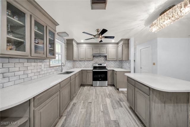 19350 Meredith Rd, North Fort Myers, FL 33917 - kitchen featuring stainless steel range with electric stovetop, gray cabinets, light wood-style floors, backsplash, and light countertops