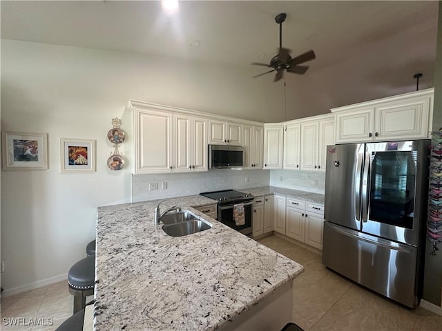4627/4629 SW 7th Pl, Cape Coral, FL 33914 - kitchen with appliances with stainless steel finishes, a ceiling fan, a peninsula, decorative backsplash, and a kitchen bar