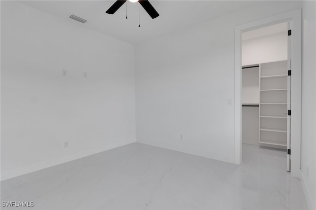 1040 NE 11th Ave, Cape Coral, FL 33909 - unfurnished bedroom featuring light marble finish flooring, a spacious closet, ceiling fan, and a closet