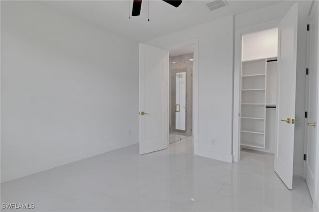 1040 NE 11th Ave, Cape Coral, FL 33909 - unfurnished bedroom with a walk in closet, light marble finish floors, a ceiling fan, and a closet