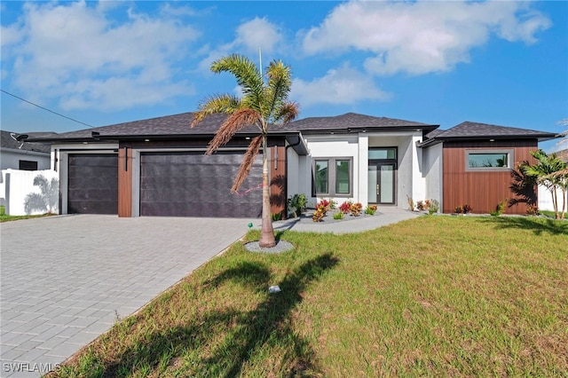 1040 NE 11th Ave, Cape Coral, FL 33909 - prairie-style home with a garage, decorative driveway, a front yard, french doors, and stucco siding