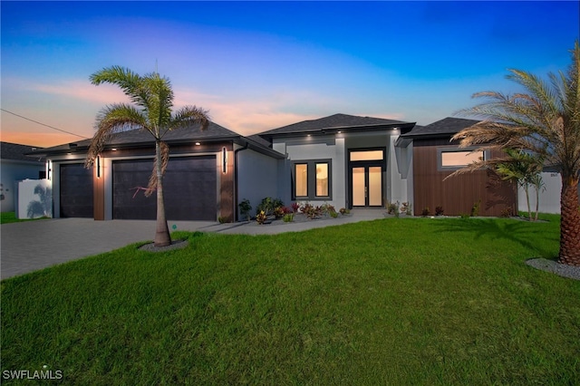 1040 NE 11th Ave, Cape Coral, FL 33909 - view of front of property featuring an attached garage, decorative driveway, a yard, and stucco siding
