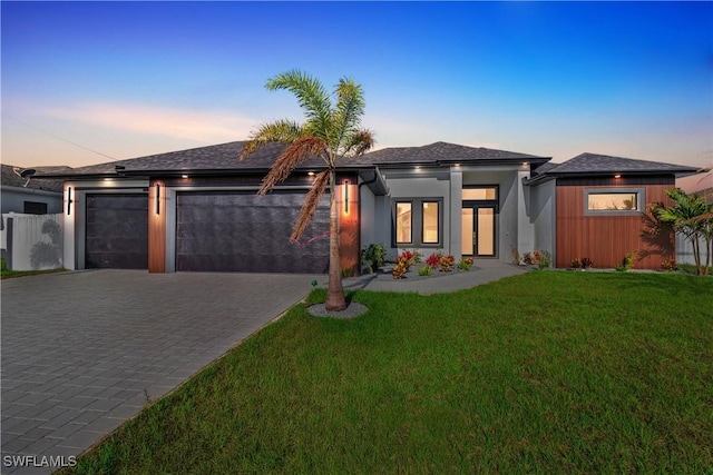 1040 NE 11th Ave, Cape Coral, FL 33909 - prairie-style house featuring an attached garage, decorative driveway, and a lawn