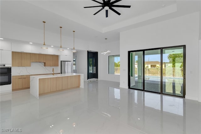 1040 NE 11th Ave, Cape Coral, FL 33909 - kitchen featuring modern cabinets, freestanding refrigerator, a ceiling fan, light brown cabinetry, and decorative backsplash