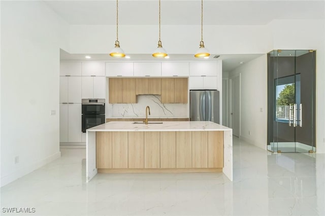 1040 NE 11th Ave, Cape Coral, FL 33909 - kitchen featuring freestanding refrigerator, modern cabinets, light marble finish flooring, and an island with sink