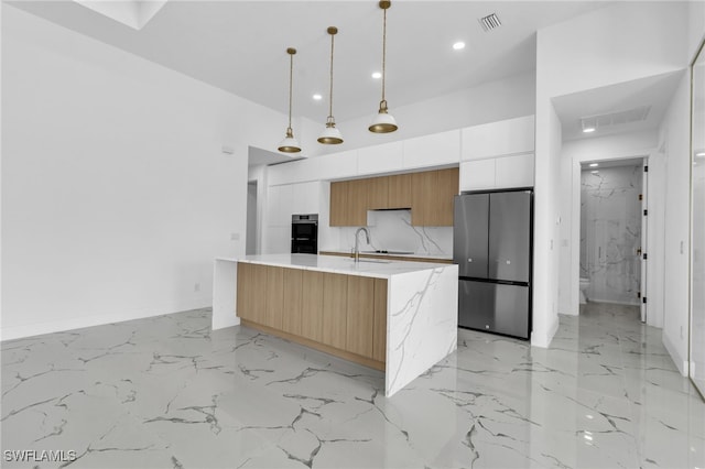 834 NW 2nd St, Cape Coral, FL 33993 - kitchen with freestanding refrigerator, modern cabinets, light marble finish flooring, recessed lighting, and decorative light fixtures
