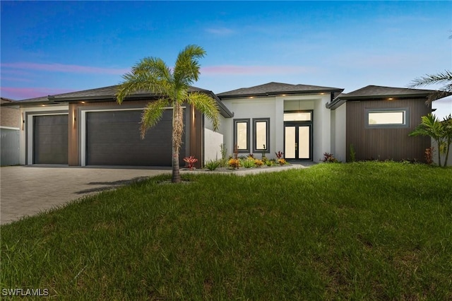 834 NW 2nd St, Cape Coral, FL 33993 - prairie-style home featuring a garage, driveway, french doors, and a front lawn