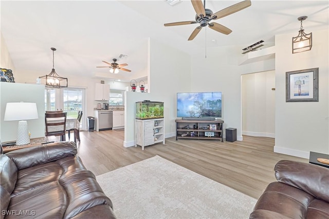 2508 Tropicana Pkwy W, Cape Coral, FL 33993 - living room with a ceiling fan, light wood-style floors, high vaulted ceiling, and a chandelier