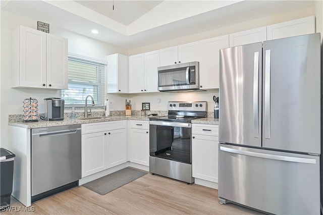 2508 Tropicana Pkwy W, Cape Coral, FL 33993 - kitchen featuring stainless steel appliances, white cabinets, recessed lighting, light wood-style floors, and light stone counters