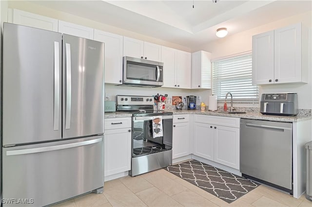 2508 Tropicana Pkwy W, Cape Coral, FL 33993 - kitchen featuring stainless steel appliances, white cabinetry, light stone counters, and light tile patterned floors