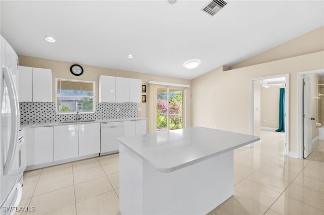 3206 8th St SW, Lehigh Acres, FL 33976 - kitchen with white appliances, decorative backsplash, a center island, light tile patterned flooring, and white cabinets