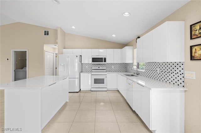 3206 8th St SW, Lehigh Acres, FL 33976 - kitchen featuring white appliances, lofted ceiling, decorative backsplash, white cabinetry, and light countertops