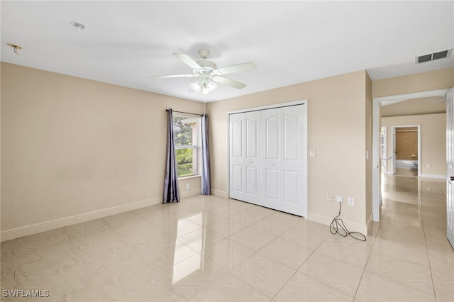 3206 8th St SW, Lehigh Acres, FL 33976 - unfurnished bedroom with a closet, a ceiling fan, and light tile patterned floors