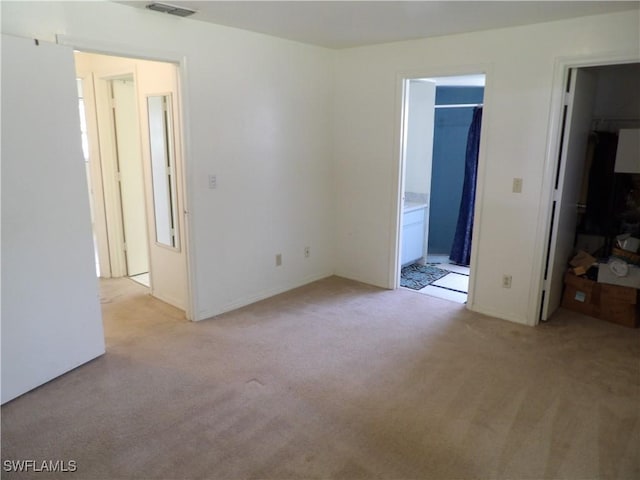 4807 6th St W, Lehigh Acres, FL 33971 - unfurnished bedroom with light colored carpet, a spacious closet, connected bathroom, and a closet