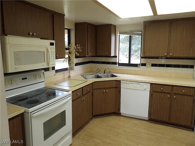 4807 6th St W, Lehigh Acres, FL 33971 - kitchen with white appliances, backsplash, light countertops, and light wood-style flooring