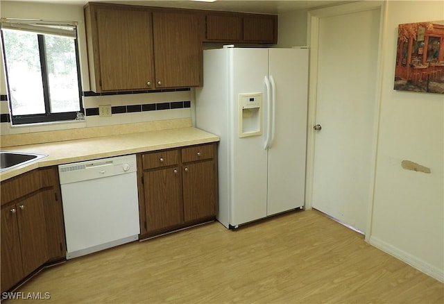 4807 6th St W, Lehigh Acres, FL 33971 - kitchen featuring white appliances, light wood-type flooring, light countertops, and backsplash