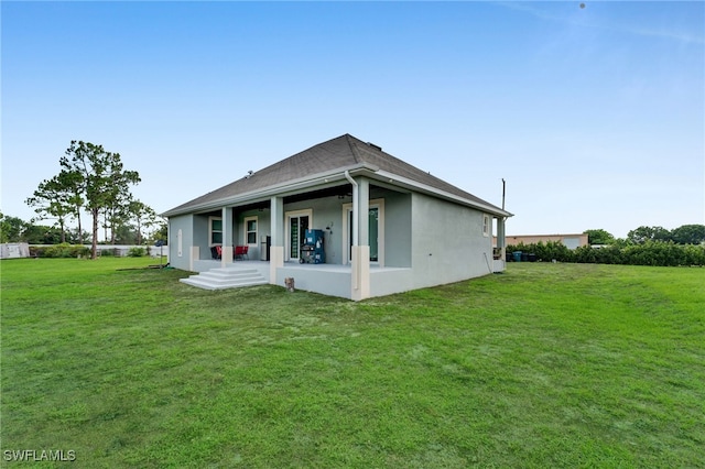 9785 Wheeler Rd, Labelle, FL 33935 - back of property featuring stucco siding, a lawn, covered porch, and a shingled roof