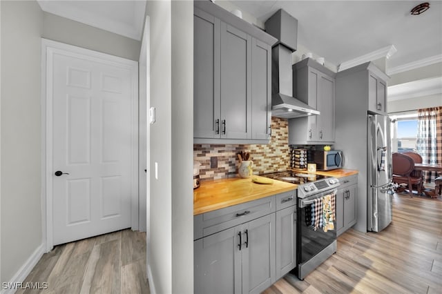 9785 Wheeler Rd, Labelle, FL 33935 - kitchen featuring stainless steel appliances, gray cabinetry, wall chimney exhaust hood, light wood-type flooring, and wood counters