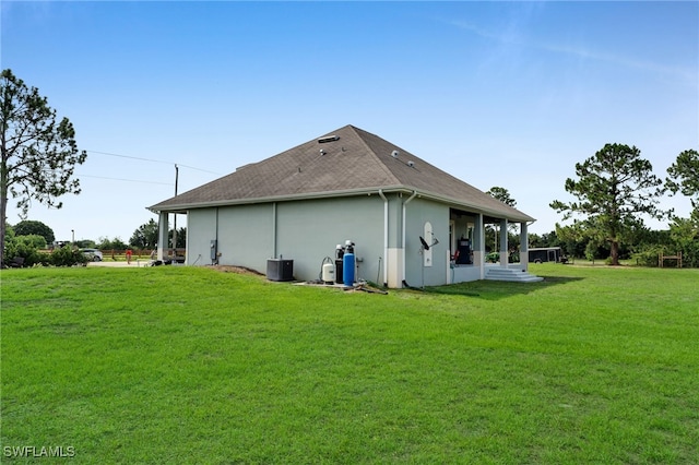 9785 Wheeler Rd, Labelle, FL 33935 - rear view of property featuring a lawn, stucco siding, and roof with shingles