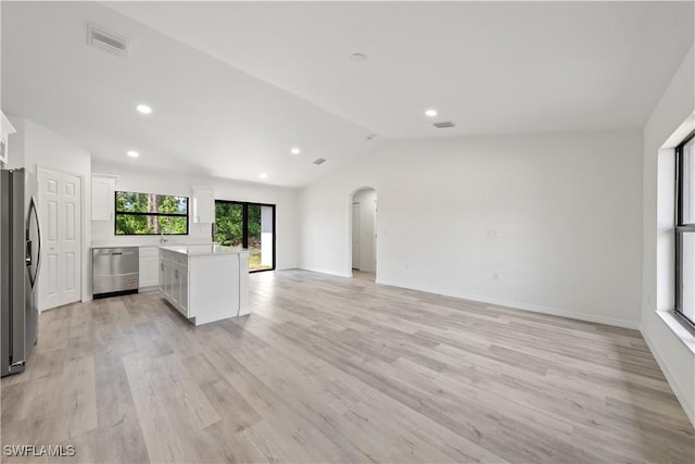 2912 8th St W, Lehigh Acres, FL 33971 - kitchen with appliances with stainless steel finishes, open floor plan, arched walkways, vaulted ceiling, and white cabinets