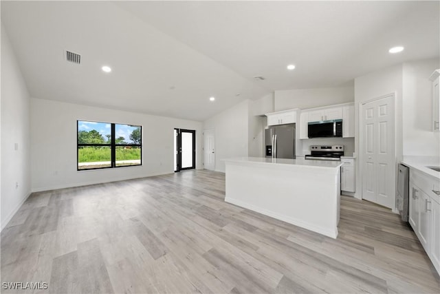 2912 8th St W, Lehigh Acres, FL 33971 - kitchen with appliances with stainless steel finishes, vaulted ceiling, a kitchen island, white cabinetry, and light countertops