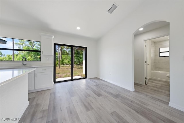 2912 8th St W, Lehigh Acres, FL 33971 - unfurnished living room featuring arched walkways, light wood-type flooring, and recessed lighting