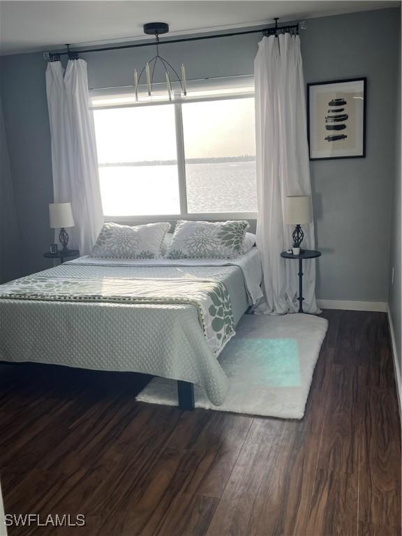 1900 Clifford St Unit 606, Fort Myers, FL 33901 - bedroom with dark wood-style floors and a chandelier