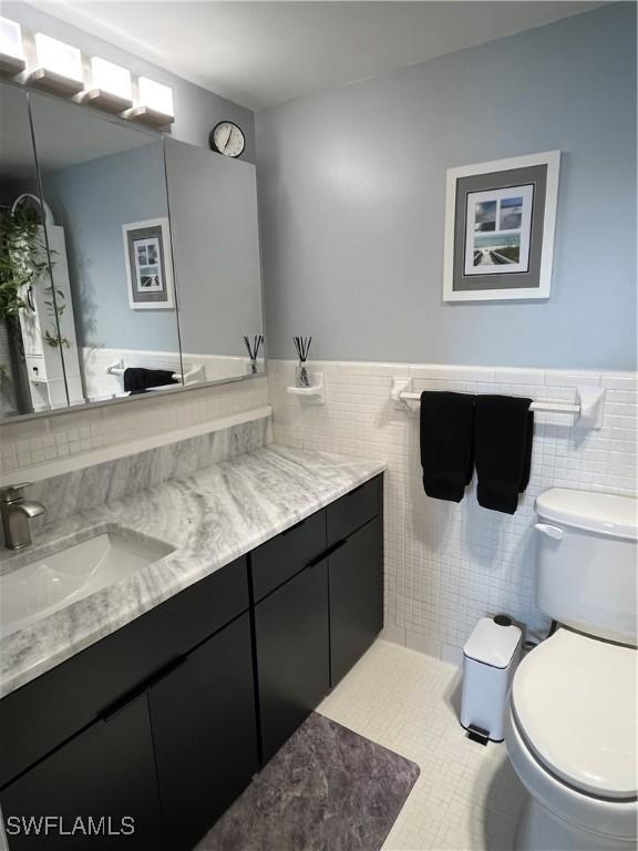 1900 Clifford St Unit 606, Fort Myers, FL 33901 - bathroom with vanity, tile walls, wainscoting, and tile patterned flooring