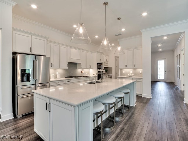 6992 Chapel Creek Ln, North Fort Myers, FL 33917 - kitchen with appliances with stainless steel finishes, white cabinetry, a large island, light countertops, and ornamental molding