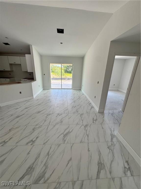 712 Oakridge Ave S, Lehigh Acres, FL 33974 - unfurnished living room with light marble finish floors and baseboards