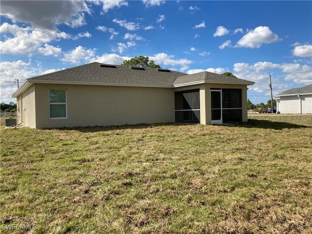 712 Oakridge Ave S, Lehigh Acres, FL 33974 - back of house featuring stucco siding, a sunroom, and a yard