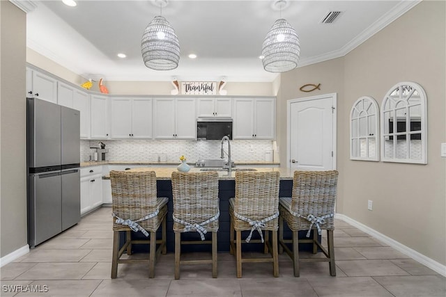 19545 Utopia Ln, Estero, FL 33928 - kitchen featuring stainless steel appliances, tasteful backsplash, white cabinets, light stone countertops, and a kitchen bar