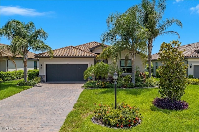19545 Utopia Ln, Estero, FL 33928 - view of front of home with stucco siding, an attached garage, a front lawn, and decorative driveway