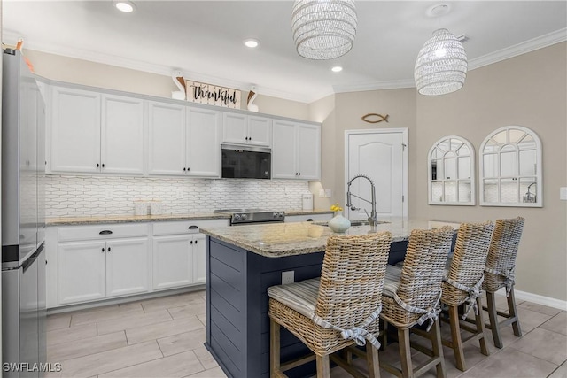 19545 Utopia Ln, Estero, FL 33928 - kitchen featuring appliances with stainless steel finishes, ornamental molding, backsplash, white cabinets, and a kitchen island with sink