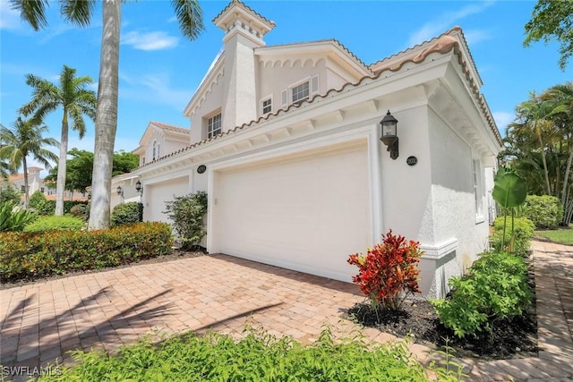 9053 Cascada Way Unit 202, Naples, FL 34114 - view of side of property with stucco siding, a garage, and decorative driveway
