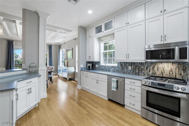 9053 Cascada Way Unit 202, Naples, FL 34114 - kitchen featuring appliances with stainless steel finishes, tasteful backsplash, light wood finished floors, white cabinets, and recessed lighting