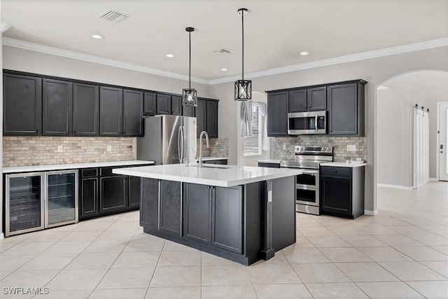 2738 Via Piazza Loop, Fort Myers, FL 33905 - kitchen featuring beverage cooler, stainless steel appliances, arched walkways, light countertops, and decorative backsplash