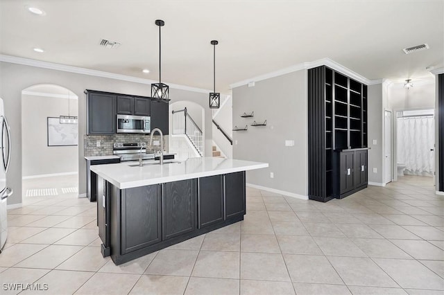 2738 Via Piazza Loop, Fort Myers, FL 33905 - kitchen with stainless steel appliances, light tile patterned floors, crown molding, light countertops, and tasteful backsplash