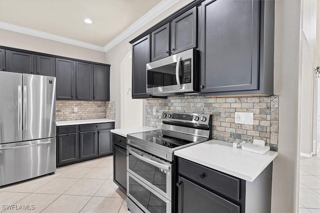 2738 Via Piazza Loop, Fort Myers, FL 33905 - kitchen featuring appliances with stainless steel finishes, light tile patterned flooring, light countertops, crown molding, and backsplash
