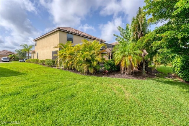 2738 Via Piazza Loop, Fort Myers, FL 33905 - view of side of home featuring a yard, a lanai, and stucco siding